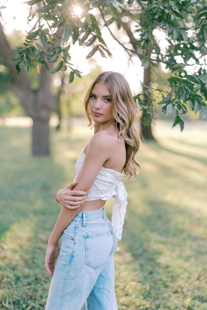 Close up relaxed portrait of senior girl posing in Malibu park with golden sunlight coming through the trees