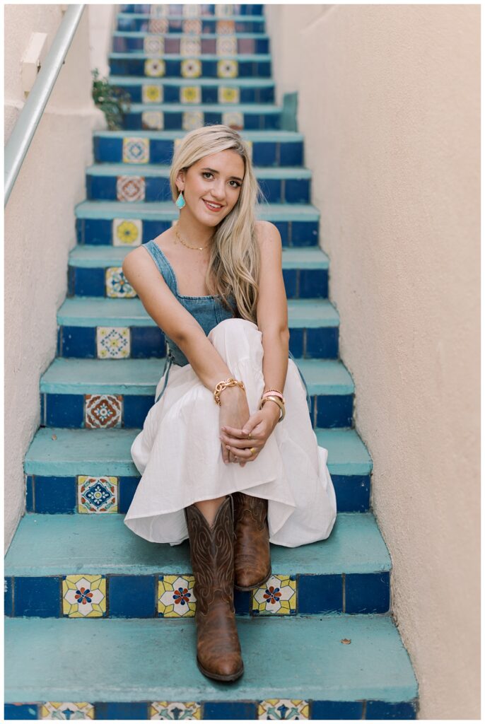 SoCal Senior portraits at urban location with bold wall and decorated stairs