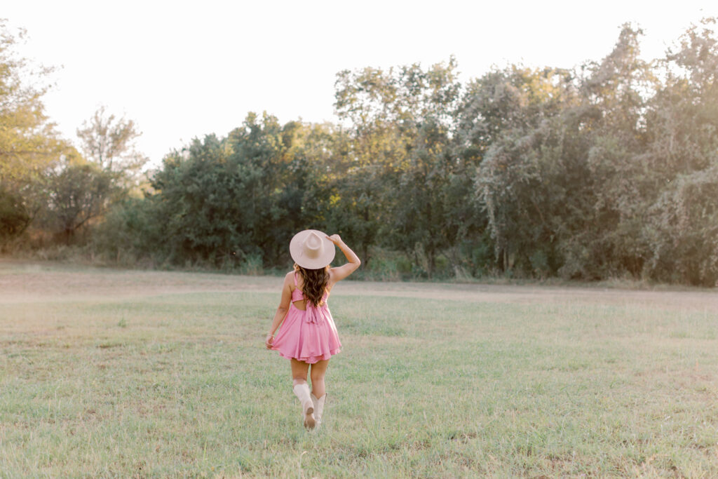 Southern California senior portrait of girl walking away from camera in pink dress and cowboy boots