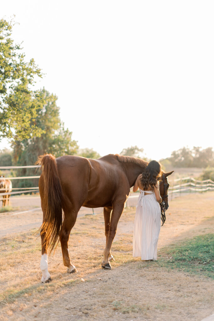Senior walking away with horse in golden hour sunset light in Southern California