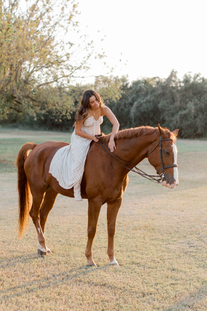 Natural portrait of high school senior grooming her horse – behind-the-scenes senior photo idea.