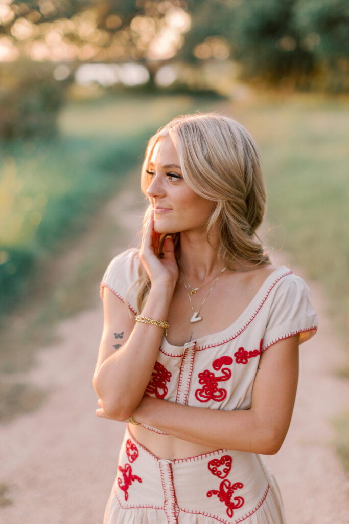 Natural light portrait of blonde high school senior with golden field
bokeh background