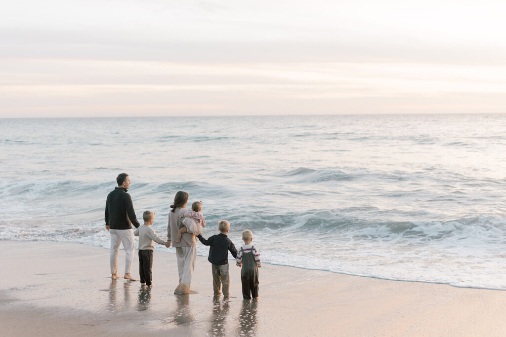 Family standing along the shoreline during a pastel sunset at Westward Beach in Malibu.