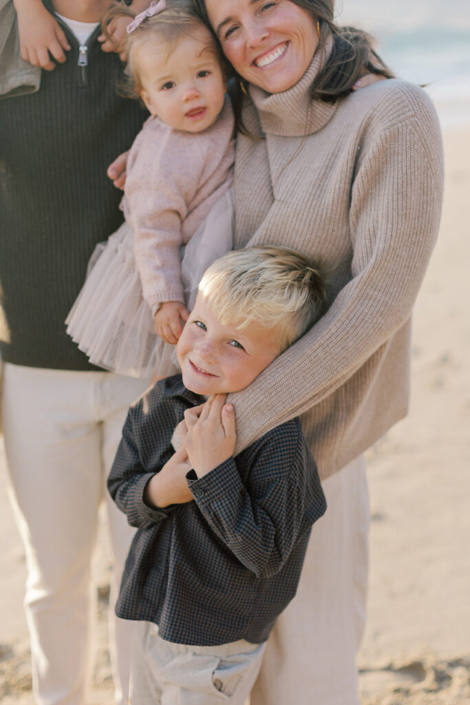 Mother hugging her young son during a warm sunset family session at Westward Beach in Malibu.
