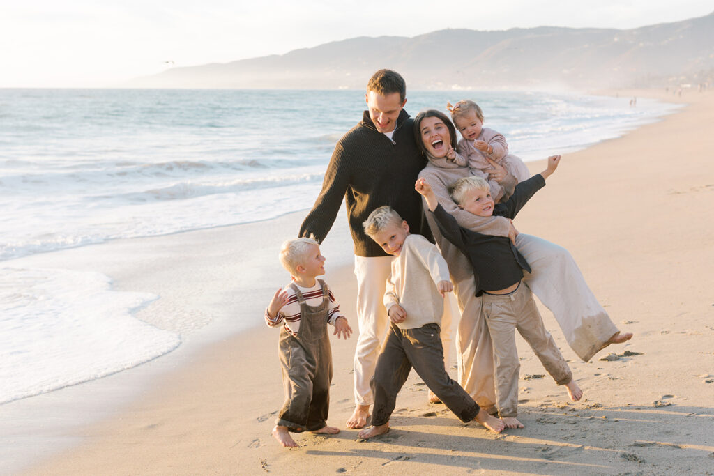 Parents hugging their children during a candid golden hour family moment in Malibu.