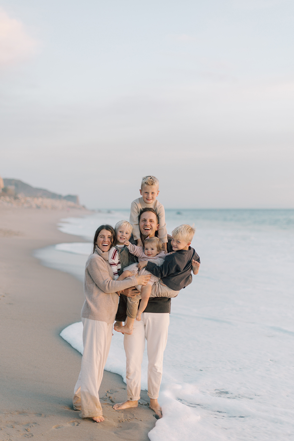 Parents holding their children and smiling together during a family session at Westward Beach.