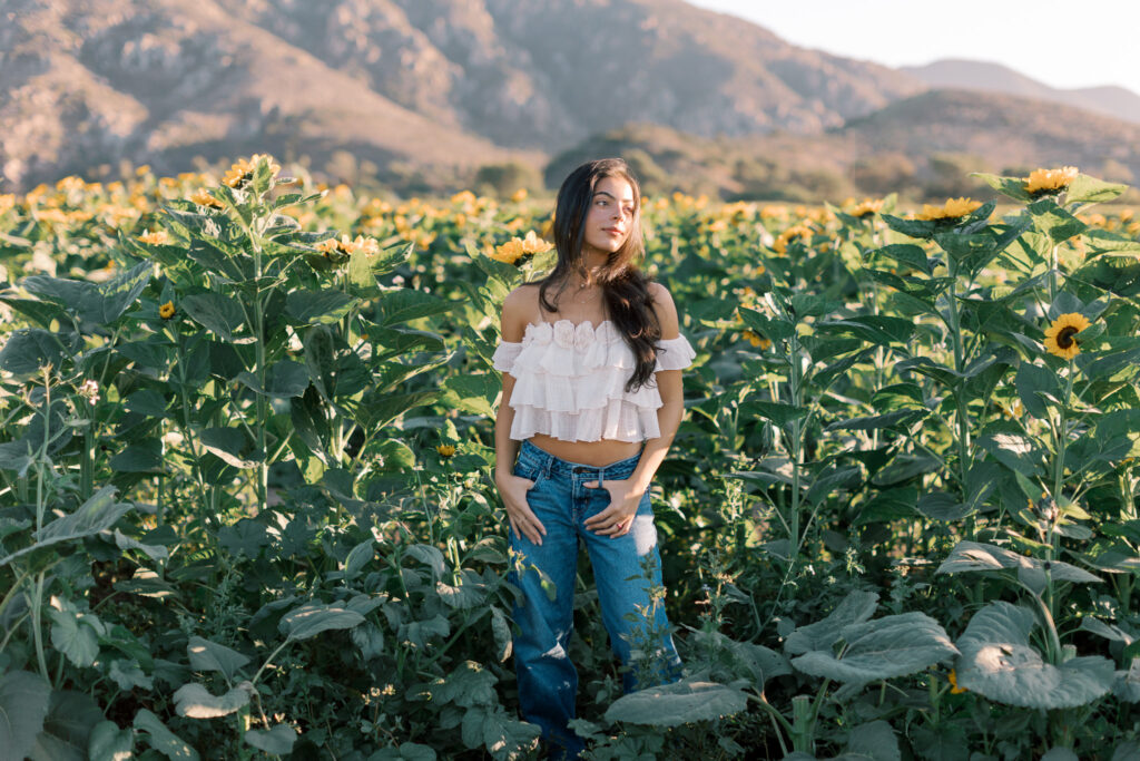 Full-length senior picture of a Westlake High School student surrounded by sunflowers photographed by a Calabasas senior photographer