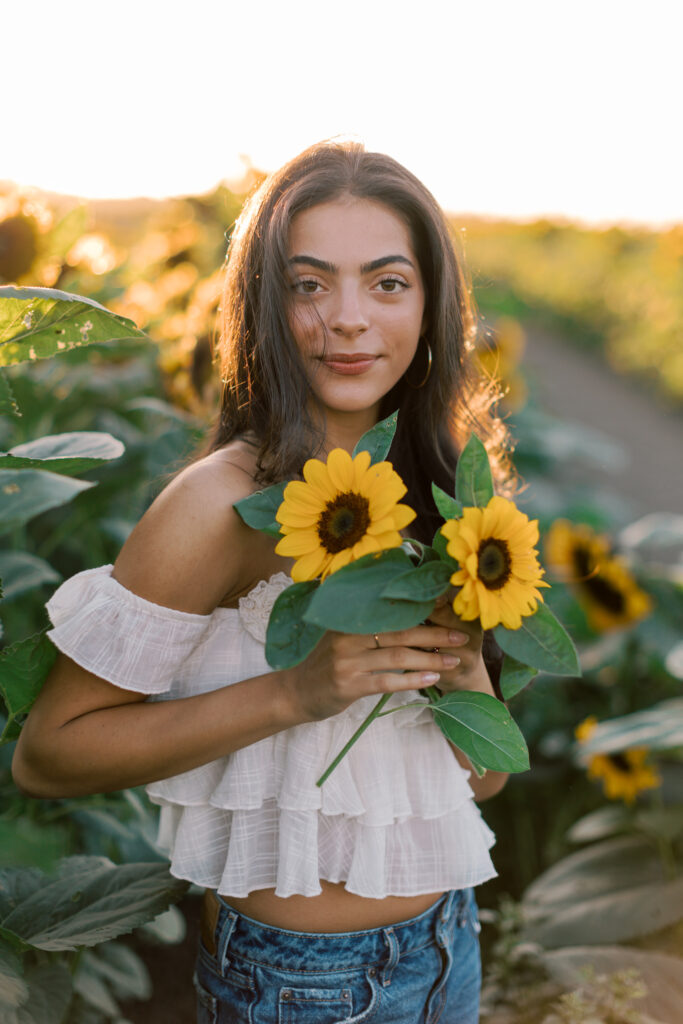 Westlake High School senior holding sunflowers during an outdoor senior session in Southern California