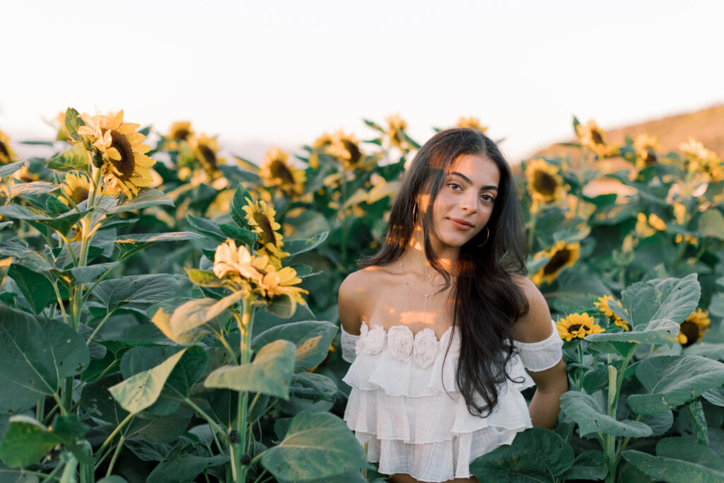 Senior portrait framed by sunflowers at Conejo Family Farms near Westlake Village California