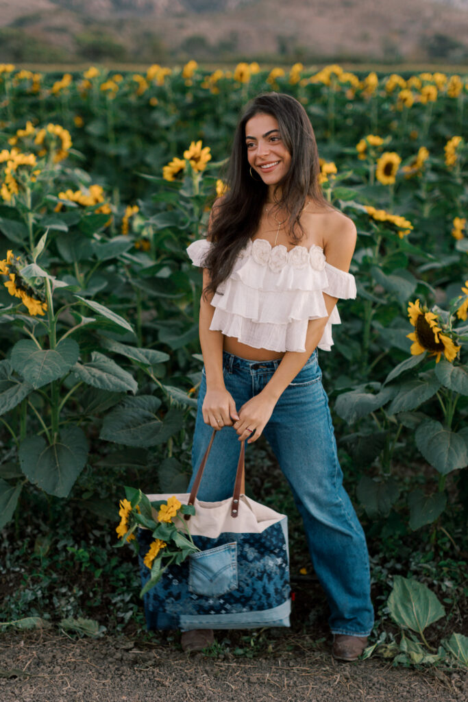 Full-length senior portrait standing among sunflowers at Conejo Family Farms near Thousand Oaks California