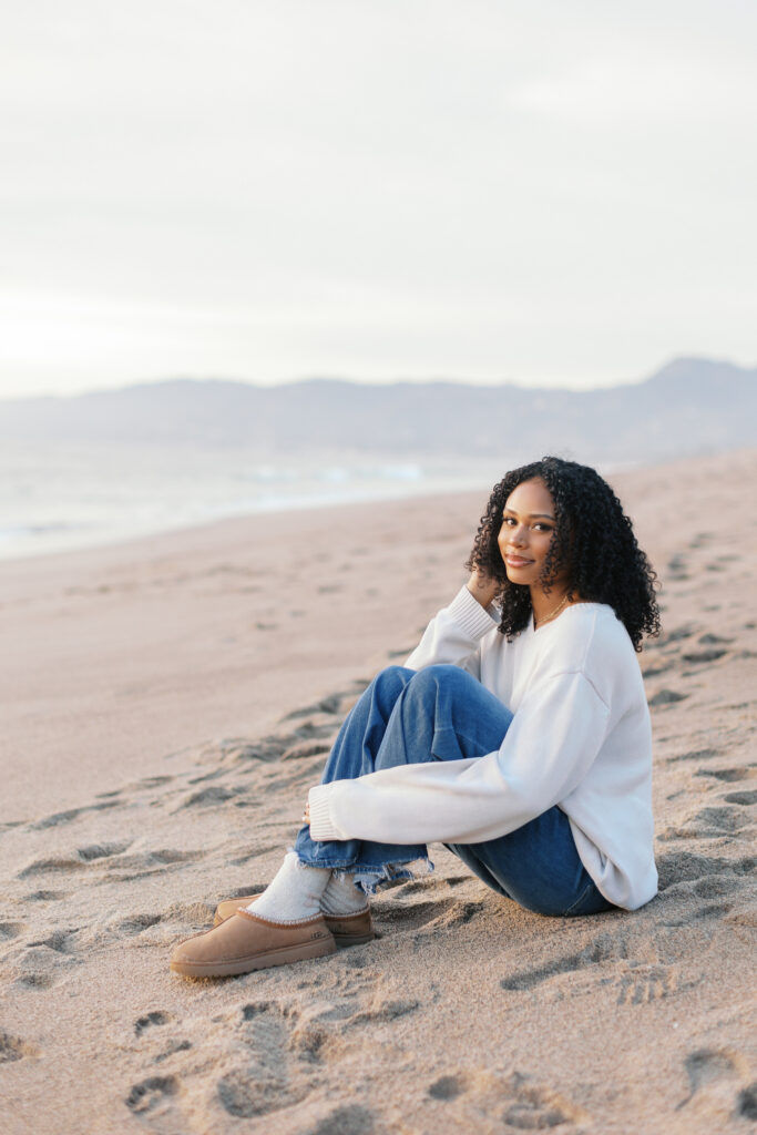 Malibu senior photos of Oaks Christian senior relaxing on the beach with natural golden hour light