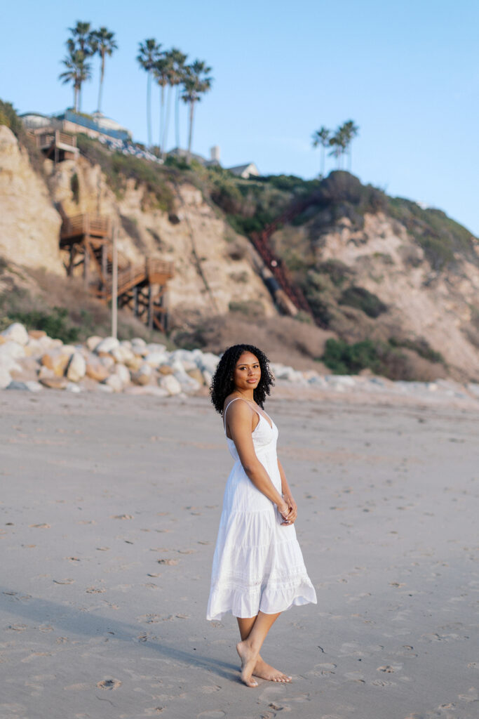 Oaks Christian senior portrait at Westward Beach Malibu with coastal cliffs and palm trees in the background