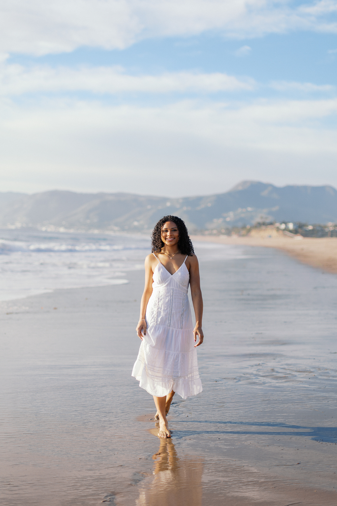 Oaks Christian High School senior walking along Westward Beach Malibu with ocean and mountains in the background