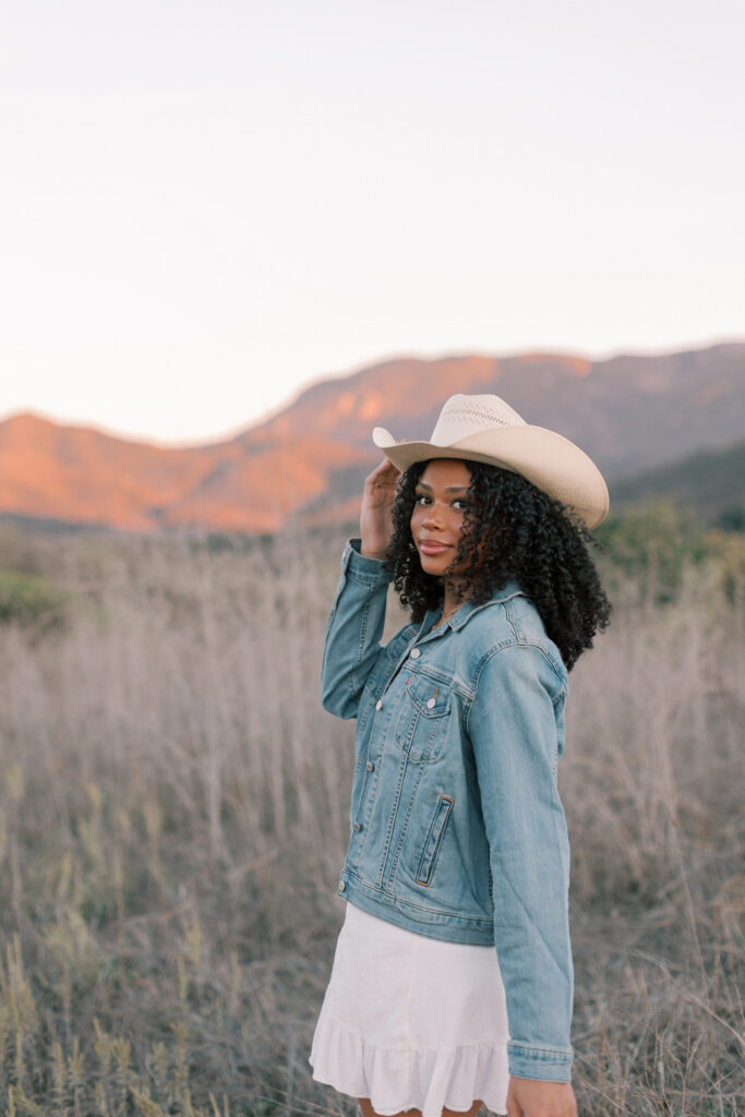 Thousand Oaks senior photos in the Santa Monica Mountains with denim jacket and western hat at sunset