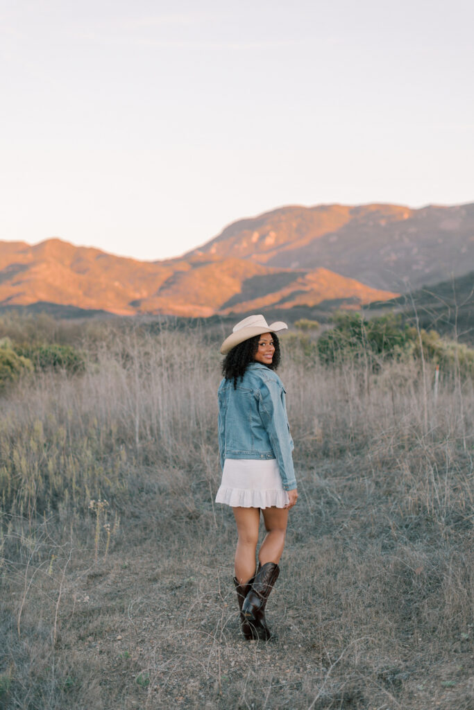 Thousand Oaks High School senior walking through a rural field in the Santa Monica Mountains at sunset in Southern California